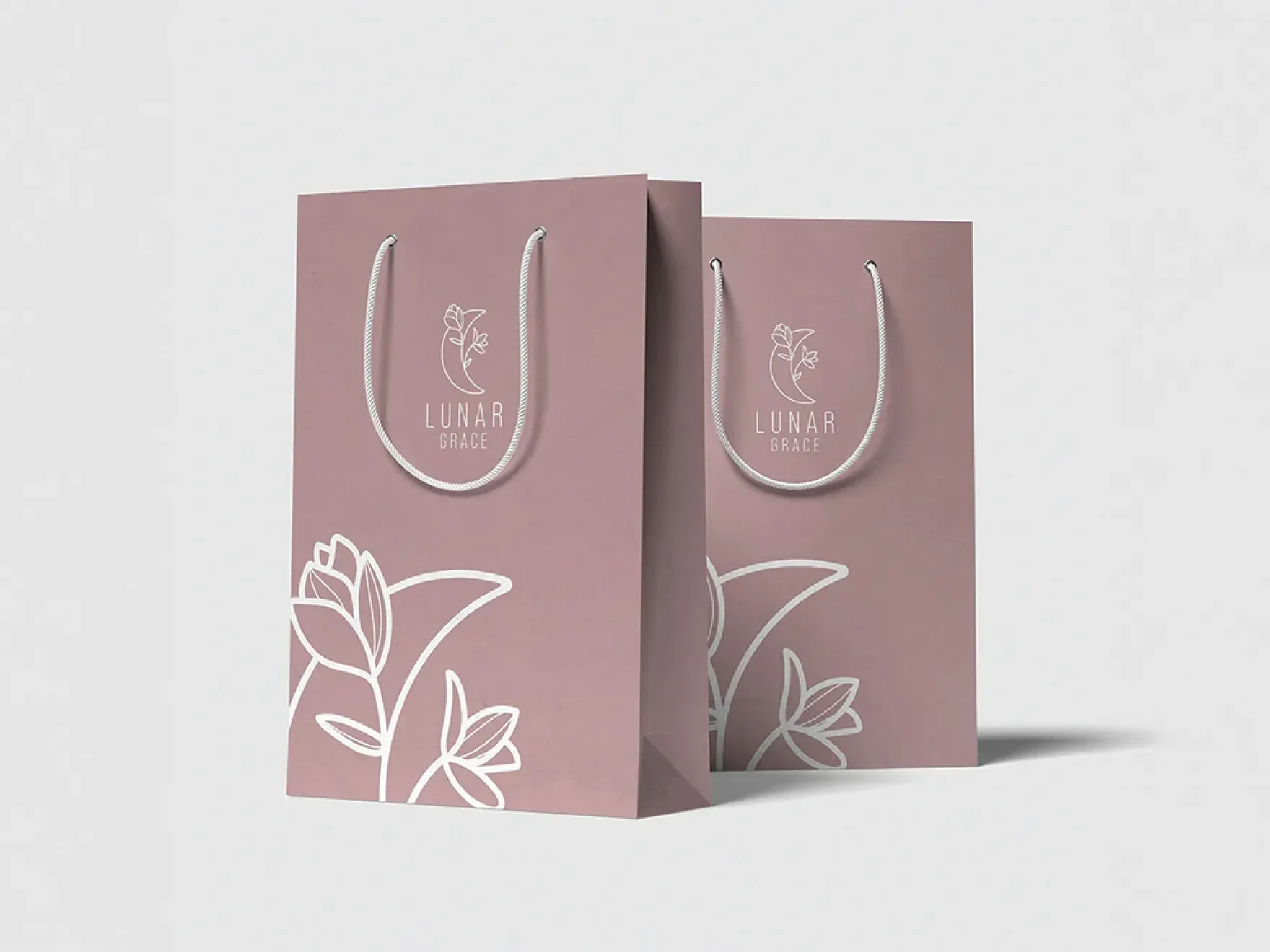 Two mauve Lunar Grace retail bags with the white line mark and wordmark.